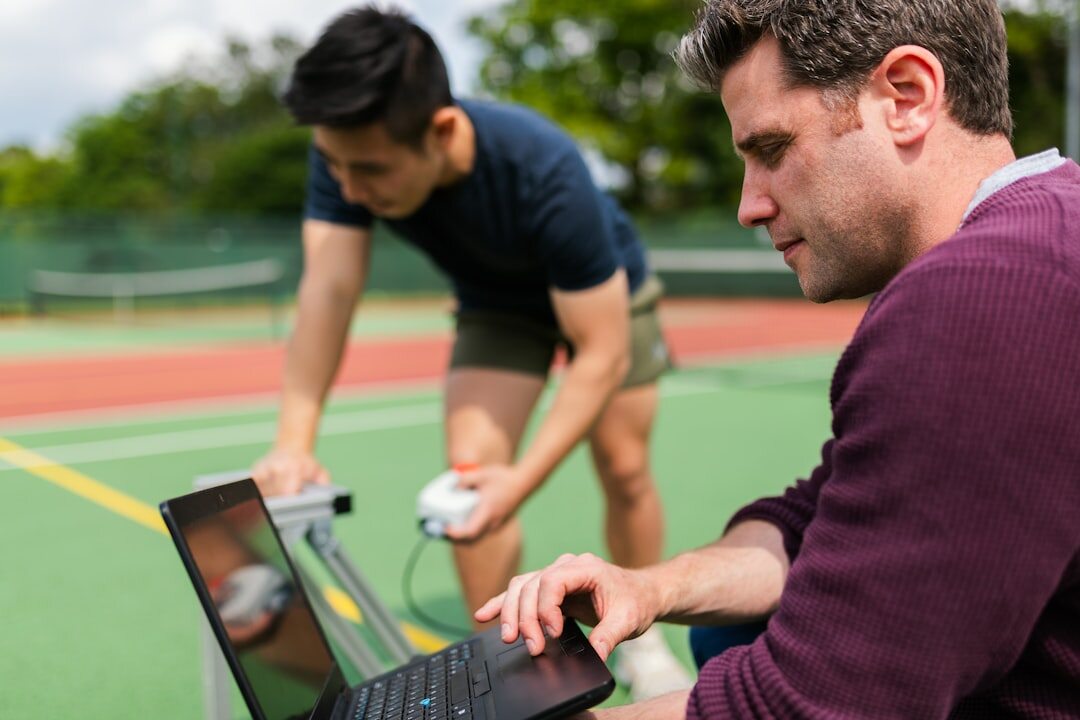 Instructor helping a professional with a laptop during training