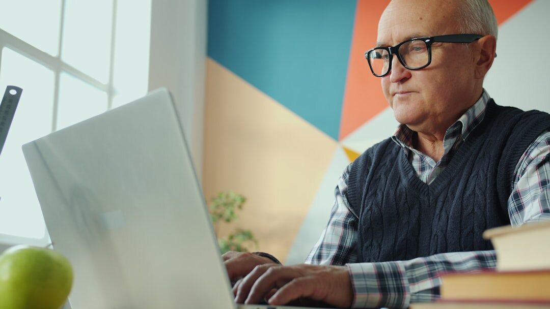 Older professional working on laptop at a desk